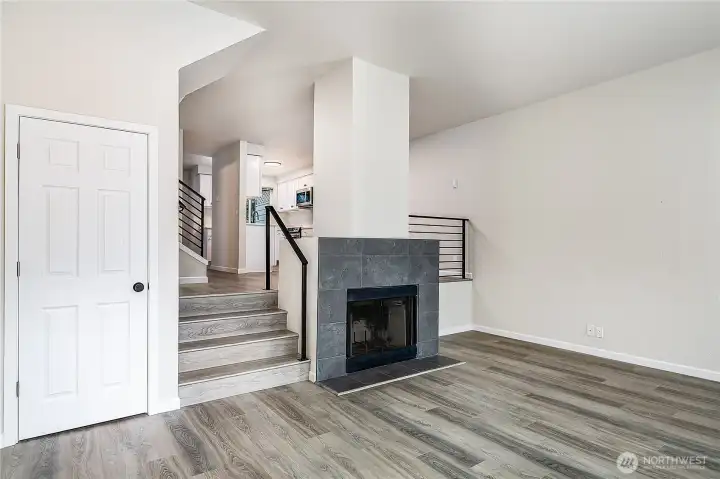 Sun-filled living room with vaulted ceilings, picture windows, and a sleek fireplace creating a modern yet cozy atmosphere.
