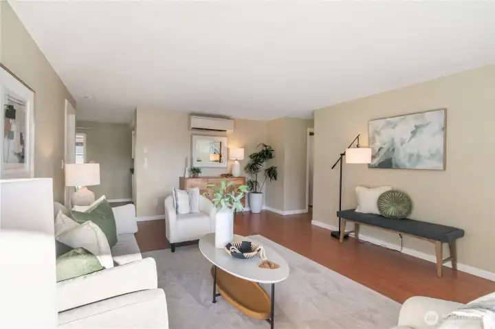 Central living room with kitchen in the back and bedrooms down the hall