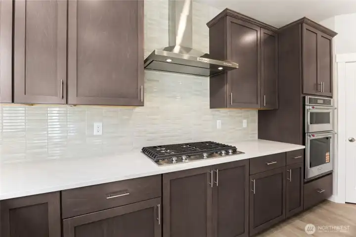 Showing plan without staging, home will include white cabinetry, includes gas cooktop, with built in microwave + oven.