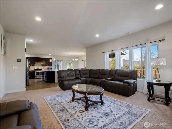 Spacious living room with abundant natural light, open to the kitchen and dining area, creating a bright and airy flow perfect for relaxing or entertaining.