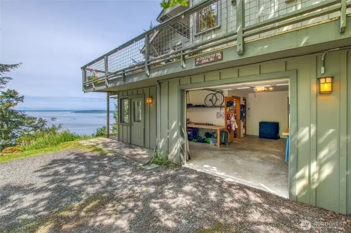 One car garage with shop area to the left and storage closet with shelving.
