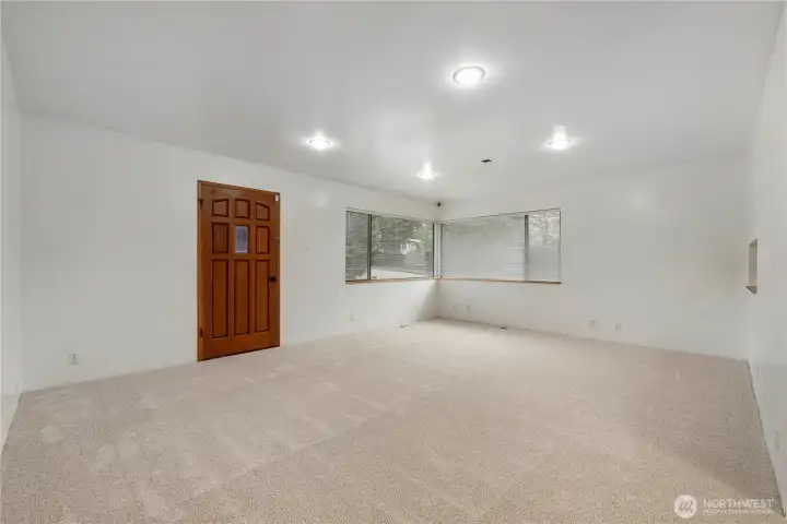 Spacious living area with fresh paint, new carpet, and recessed lighting—ideal for flexible furniture layouts and everyday comfort