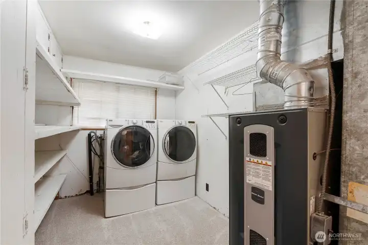 Functional laundry area featuring built-in shelving and convenient storage.