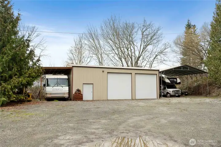 Expansive gravel area with large shop and ample room for parking, equipment, or trailers.