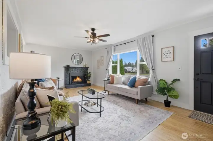 Light-filled living room with gas fireplace and large picture windows.