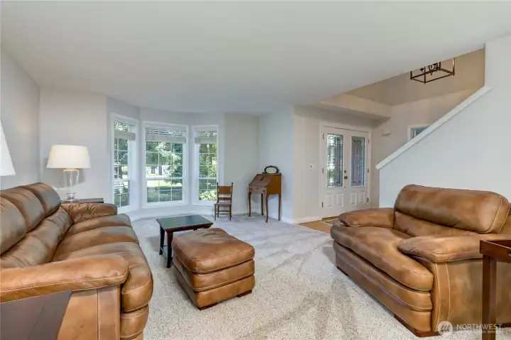 Living room includes large windows overlooking the beautiful front yard.