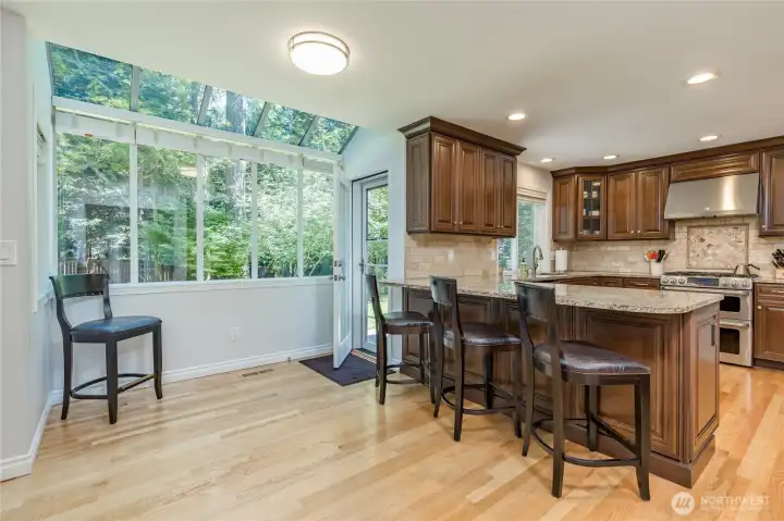 Sunny breakfast nook designed to bring the outdoors in with its abundant natural light and wide views of your gorgeous backyard.
