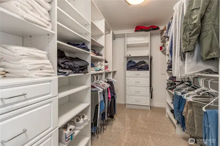 Generous walk-in closet with convenient adjustable organizer system.