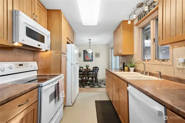 Fully equiped kitchen with refrigerator, oven, and conveniently wall-mounted microwave for effortless cooking.