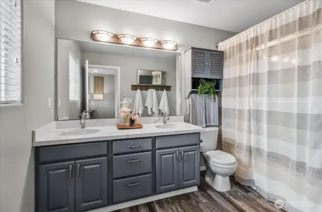Primary bath with double sinks and a window for added light.