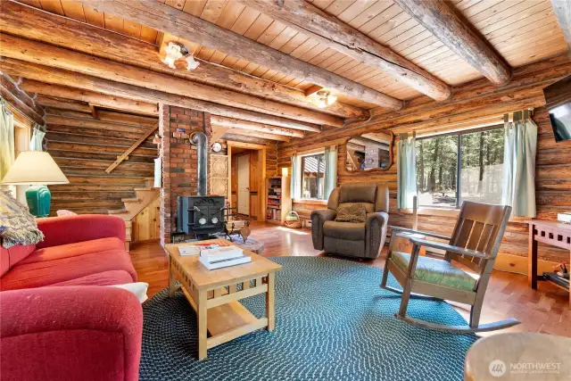 The cozy living room occupies the original cabin with stairs up to the sleeping dormer or down to an additional bedroom.