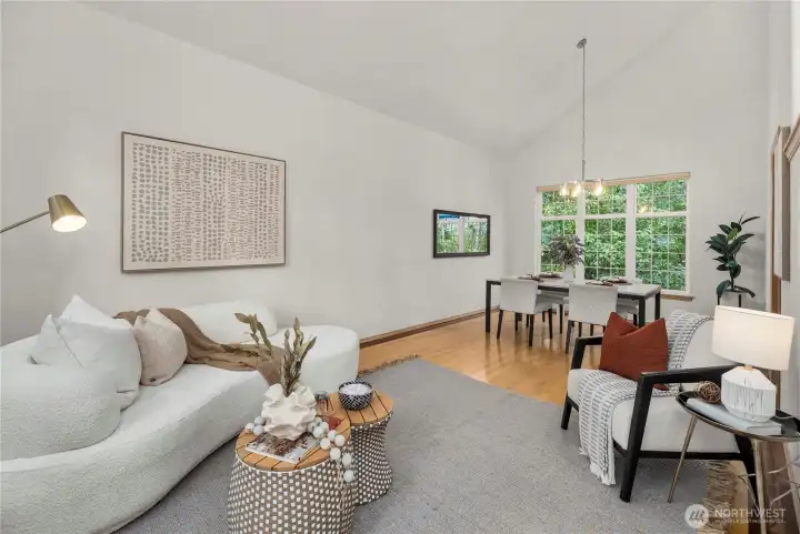 Bright living area adjacent to a formal dining room with vaulted ceilings, creating a warm and elegant atmosphere.