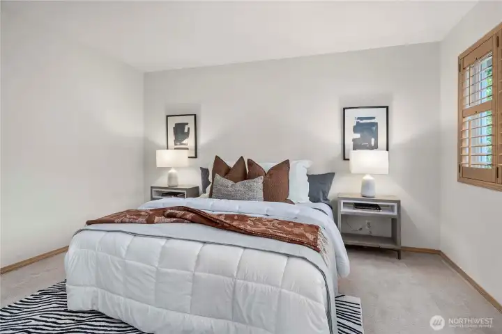 Primary bedroom featuring charming wood shutters that add warmth and timeless style.
