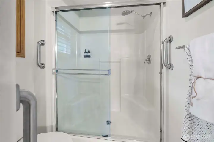 Thoughtfully equipped with grab bars, the shower offers both comfort and accessibility.