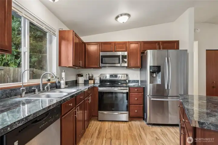 Cherry cabinetry, stainless appliances give the kitchen a warm, polished feel. Whether you're cooking a quick meal or hosting a dinner party, this space supports both function and style. Range is 2 years old.