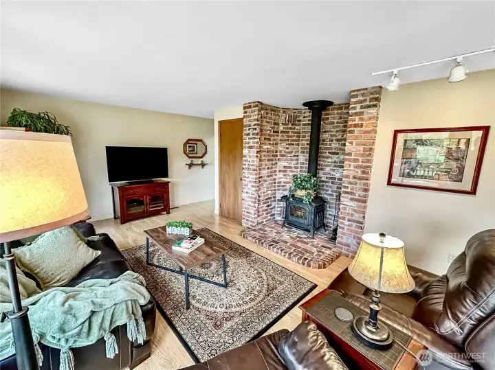 On the back side of the home sits the inviting family room with laminate floor, Resolute certified wood burning stove with brick surround and access to the large composite deck.