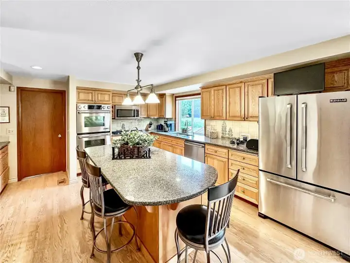 Updated kitchen with rich laminate floor, quartz counters, stainless appliances, new cabinets and light fixture.