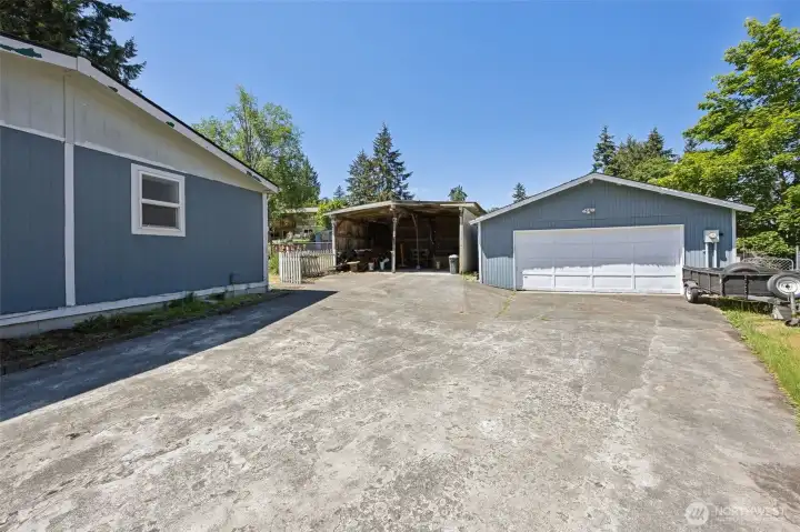 Large driveway on side on home leads to detached and open bay garages offer abundant parking.