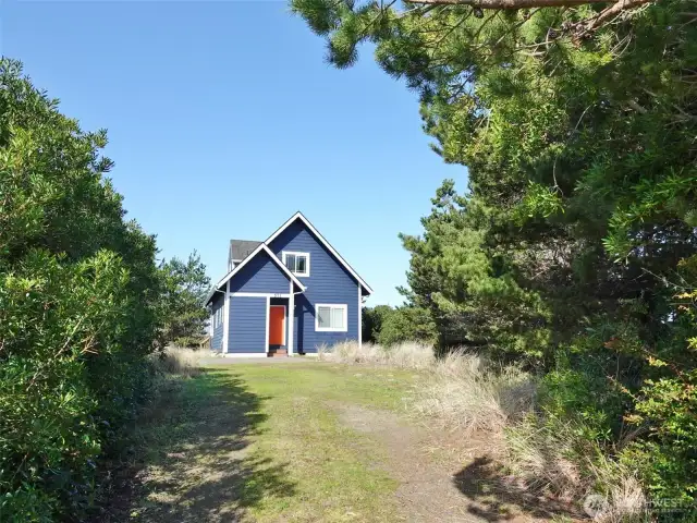 Front of this home situated with a wall of natural vegetation to provide privacy from the street.