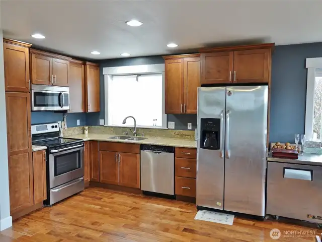 Kitchen w/ Stainless Steel Appliances and Slab Granite Counters.