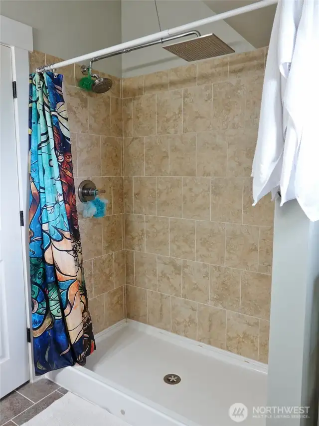 Upstairs Bathroom walk-in shower with tile walls.