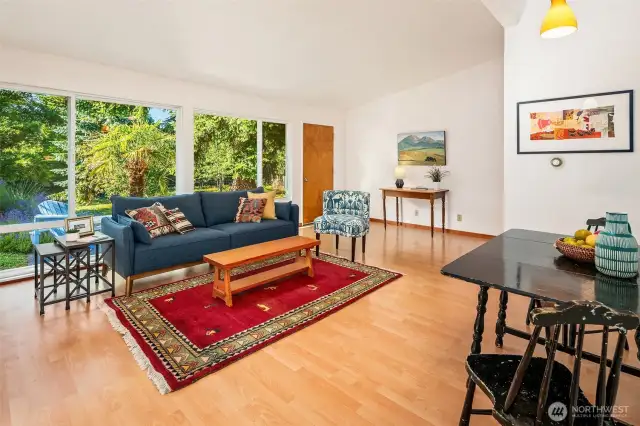 The great room enjoys huge windows looking out onto the private patio and sweet landscape. Vaulted ceilings add to the spacious and generous feel.