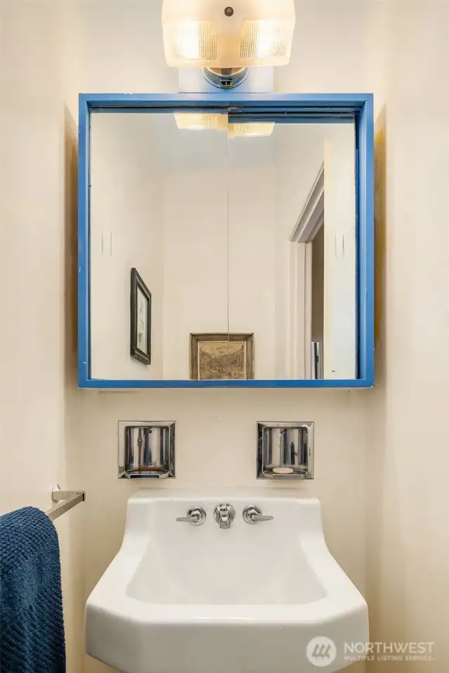 Powder room off the hallway. Vintage sink fixture original to the home. So cute!