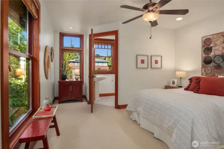 This cheerful upper-level bedroom offers warmth and comfort, featuring abundant natural light and a private ensuite for added convenience.