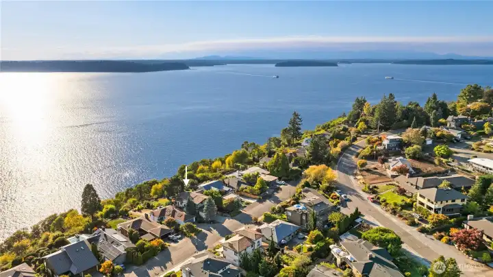 The location offers unobstructed views of the shimmering water, passing ferries, Vashon & Blake Islands, all framed by the peaceful Arroyos neighborhood.