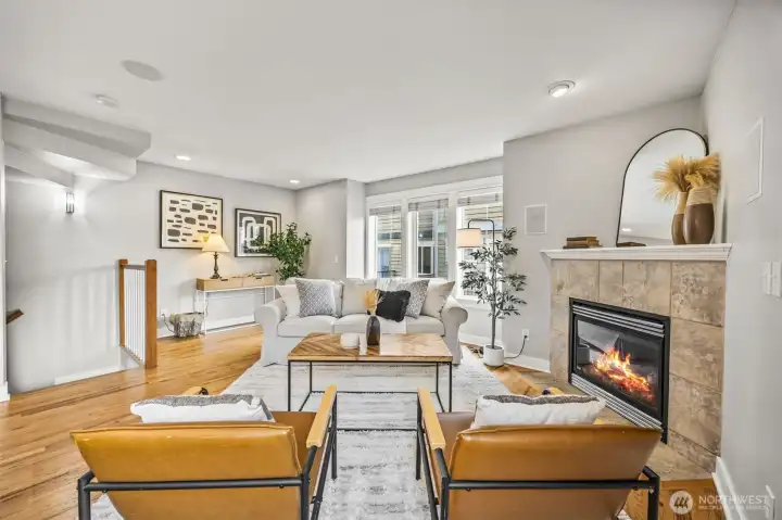 Light-filled living space with generous windows and a cozy, gas fireplace.