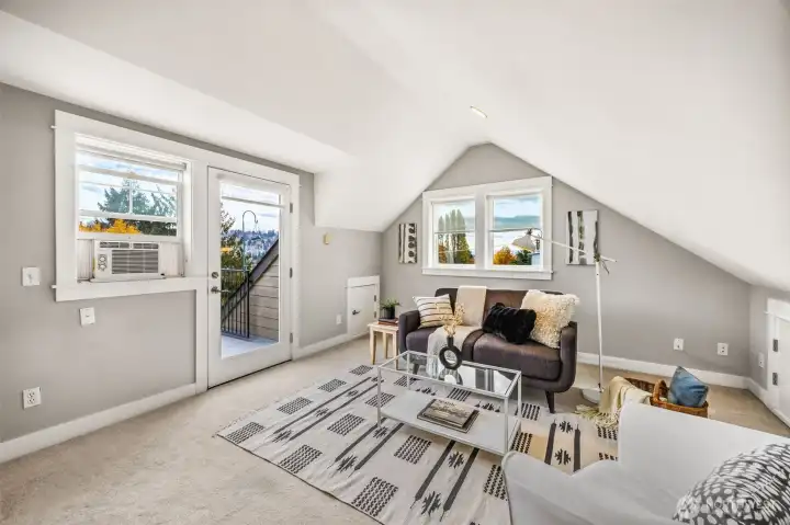 Elevated top-floor retreat filled with natural light and private deck.