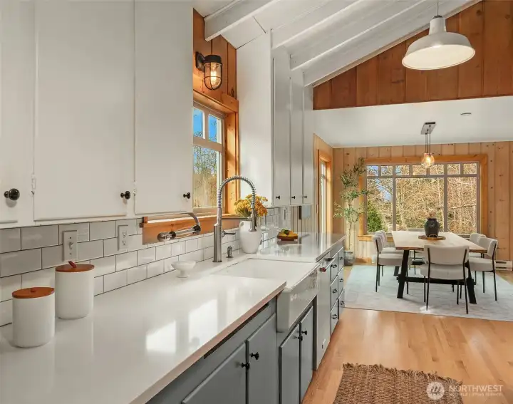Updated kitchen with quartz counter tops, farmhouse sink, vaulted ceilings and wood floors.