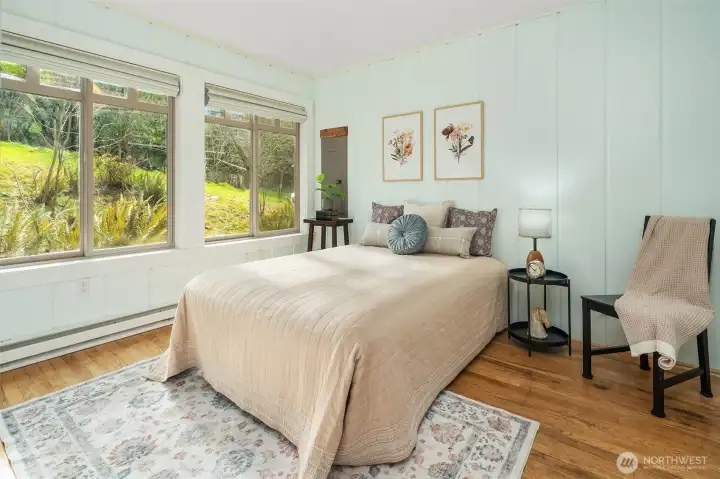 One of two bedrooms off the main living area. Hardwood floors and huge windows. Painted board walls. Very charming.