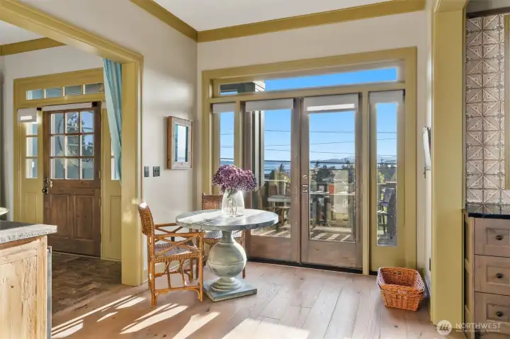 The kitchen features elegant French doors that open directly onto a west-facing view deck, creating a seamless connection between indoor and outdoor living. This inviting space is ideal for savoring a quiet morning coffee as the day begins or unwinding with a cold drink while taking in the evening light after a long workday.