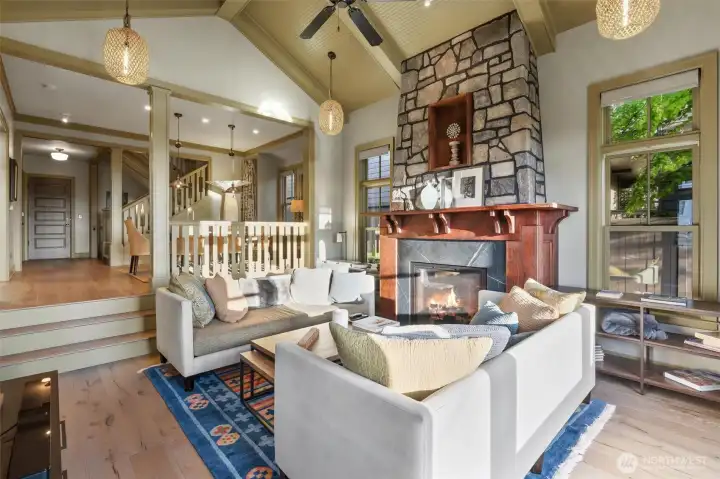 The warm and inviting living room flows seamlessly into the dining area, while the thoughtfully designed railing provides a subtle sense of separation without disrupting the open feel. A remote-controlled gas fireplace adds both comfort and convenience, creating the perfect ambiance and a cozy retreat during the winter months.