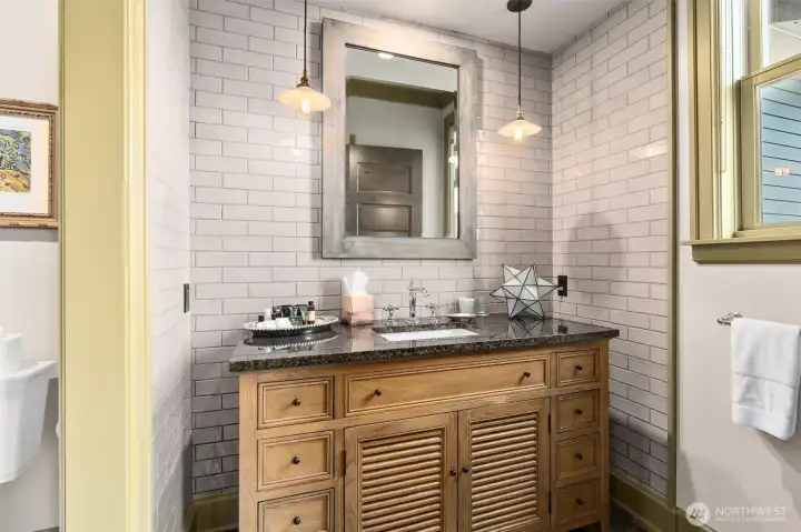 This full en-suite bathroom in one of the two guest rooms, thoughtfully designed for comfort and convenience. While you’re at the property, be sure to take in the fabulous water view framed by the window to the right—a beautiful reminder of the home’s exceptional setting.