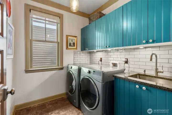 The laundry room, located on the top floor, is well-appointed with a utility sink and ample storage. In addition, the home is thoughtfully designed for flexibility, with two additional spaces pre-plumbed for future laundry areas-one in the primary walk-in closet and another in the lower-level studio.