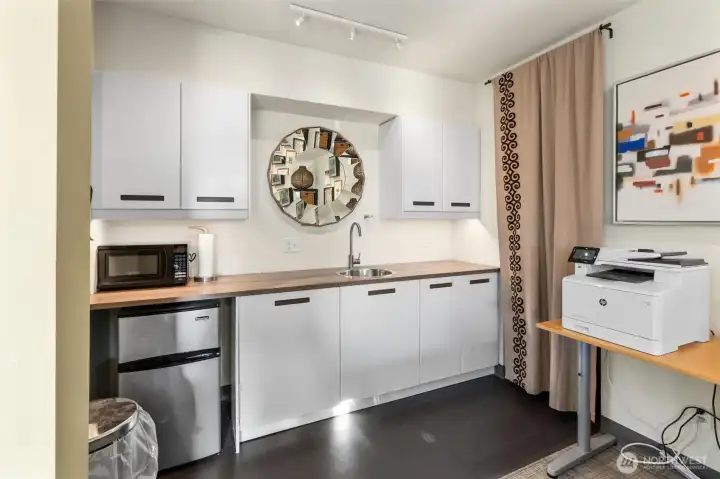 The lower-level studio is connected to the main home by an extra-wide staircase and also offers a separate entrance for added flexibility. It includes a partial kitchen with room to expand, making it well-suited for a variety of uses. This versatile space is ideal for multigenerational living or as a dedicated work-from-home area—currently used as such by the seller.