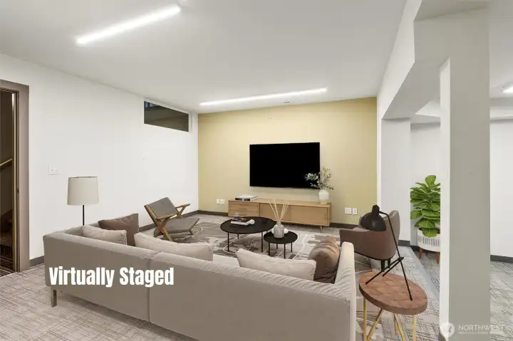 This section of the lower level was thoughtfully designed as a media room with sunken seating, creating an inviting and immersive space for relaxing or entertaining. With its partial kitchen, full bath, separate entrance, and generous proportions, the possibilities are truly endless—whether used as a media lounge, guest suite, or flexible living area to suit a variety of needs.