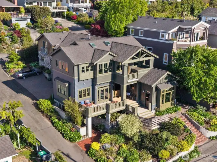 From this angle, you can see the brick entry leading to the lower level, along with the view decks on both the main and upper levels. The beautifully landscaped and terraced grounds further enhance the property, adding charm, dimension, and exceptional curb appeal.