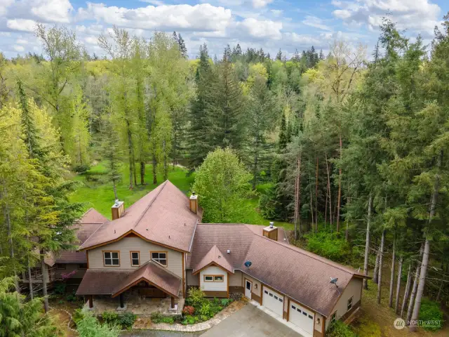 Situated on over 11 acres, this gorgeous 2-story home with a basement is surrounded by towering evergreens and nature.