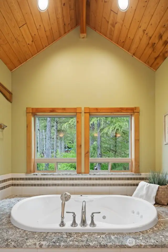 The jetted soaking tub looks out to the forested area and nature and is so serene.