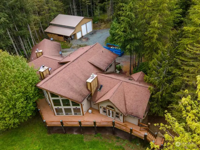 An aerial view shows the large home and the spacious shop with 220 power.