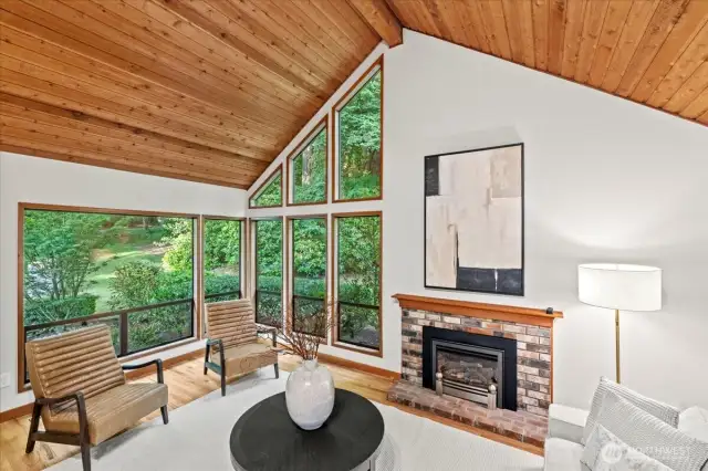 The formal living room exudes warmth and light with it's wood clad ceiling, floor to ceiling windows and natural gas fireplace. Just imagine the holiday gatherings and memories you can create in this home.