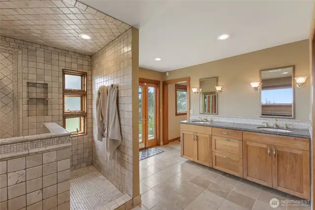 2 headed shower with tumbled marble and a granite bench.