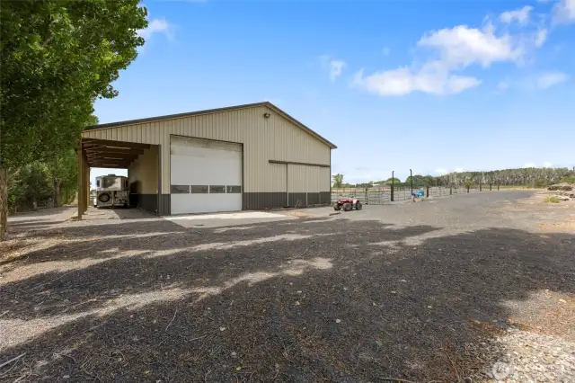 Backside of the barn with horse trailer drive through storage. This barn has outdoor lights that allow for evening riding in the arena.