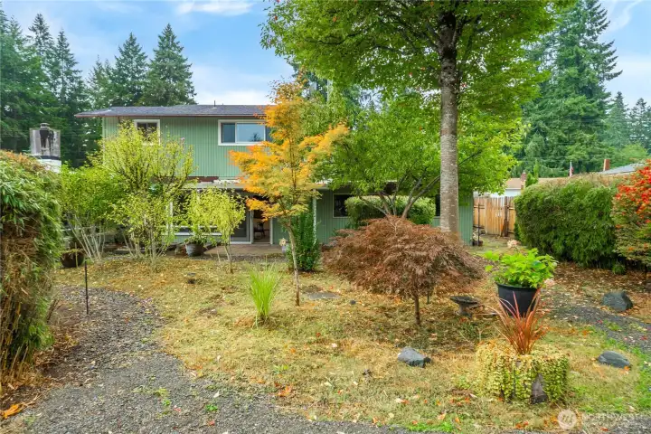 Enjoy a low-maintenance yard featuring mature landscaping and natural beauty