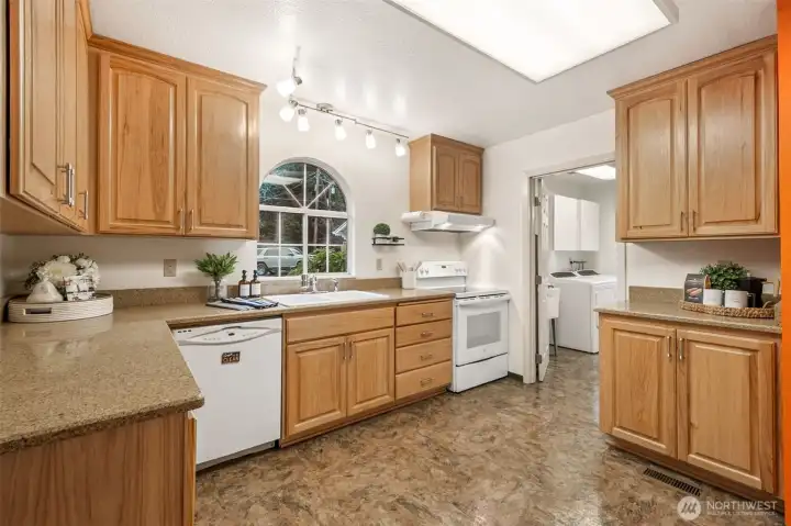 With its quartz counters, hickory cabinets, and sunny window above the sink, this kitchen blends beauty with functionality. The ample prep space and storage make it a standout feature for those who love to cook or entertain.