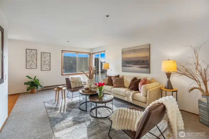 Spacious living room with big windows, lots of natural light & balcony with a view of the Olympic Mtns, Puget Sound & gorgeous sunsets. Freshly painted & new carpet throughout.