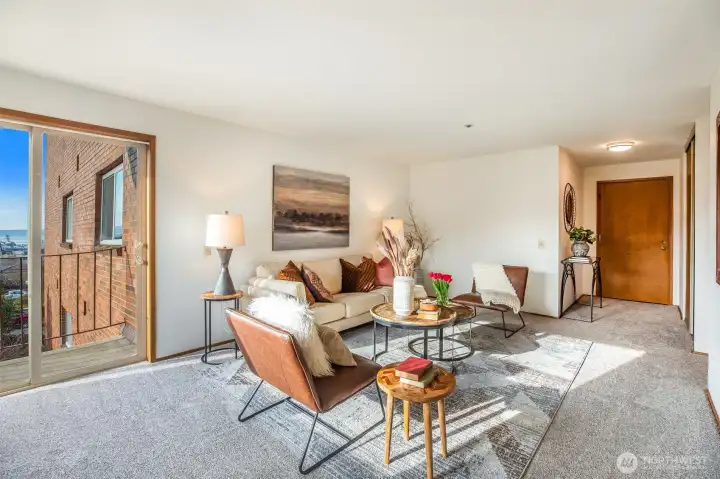 Spacious living room with big windows, lots of natural light & balcony with a view of the Olympic Mtns, Puget Sound & gorgeous sunsets. Freshly painted & new carpet throughout.